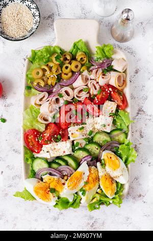 Salade cobb saine avec jambon, concombre, tomate, olives, feta et œufs. Déjeuner cétogène. Vue de dessus, au-dessus de la tête Banque D'Images