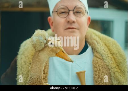 Portrait d'un vétérinaire masculin tenant un beau canard dans ses mains. au ranch Banque D'Images