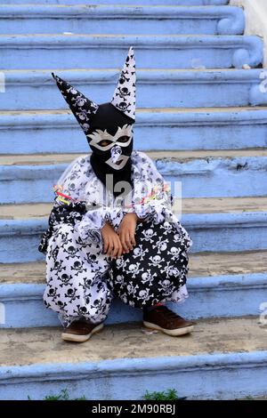 Maragogipe, Bahia, Brésil - 27 février 2017: Une personne portant un costume assis sur les escaliers dans la ville de Maragogipe, Bahia, pendant le carnaval Banque D'Images