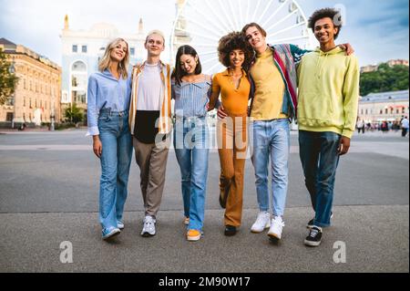 Les jeunes multiraciaux ensemble de réunion et de rassemblement social - Groupe d'amis avec des races mixtes ayant l'amusement en plein air dans la ville - amitié et lif Banque D'Images