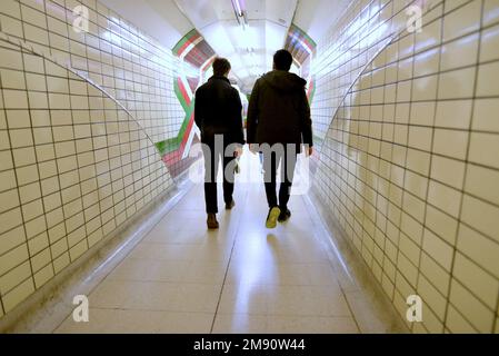 Londres, Angleterre, Royaume-Uni. Deux hommes marchant dans un tunnel dans une station sur la ligne Bakerloo Undergarnd Banque D'Images