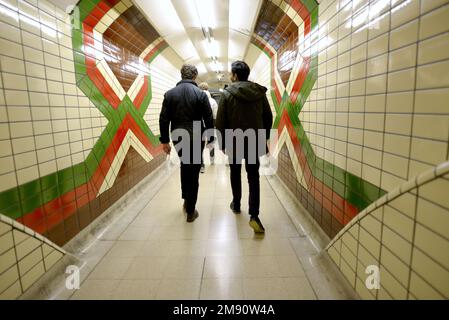 Londres, Angleterre, Royaume-Uni. Deux hommes marchant dans un tunnel dans une station sur la ligne Bakerloo Undergarnd Banque D'Images