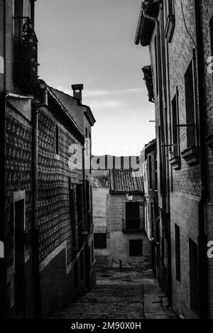 Vue verticale sur les toits de silhouette des bâtiments historiques depuis une rue étroite avec une petite cheminée, à Segovia, Espagne Banque D'Images