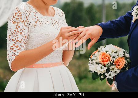 échange d'anneaux d'or lors de la cérémonie de mariage entre la mariée et le marié Banque D'Images