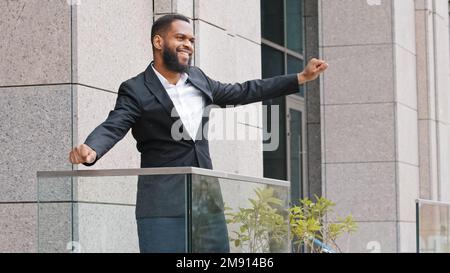 Joyeux drôle joyeux entrepreneur ethnique africain dirigeant célébrer les bonnes nouvelles gagnant la victoire avec la danse drôle. Homme d'affaires américain Banque D'Images