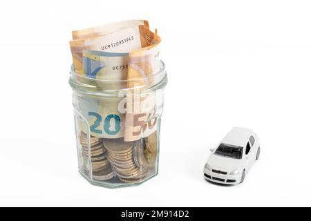 Modèle miniature de voiture et relevé financier avec pièces. Financement et prêt de voiture, économiser de l'argent pour une voiture ou des concepts de conception de matériel. Banque D'Images