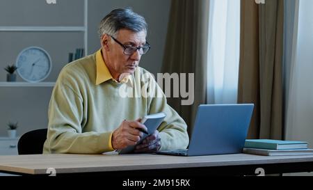 Vieil homme de race blanche enseignant avec ordinateur portable parlant en webcam apprentissage à distance conférence vidéo appel conférence de tête de séminaire en ligne conférence pour les étudiants de l'université Banque D'Images