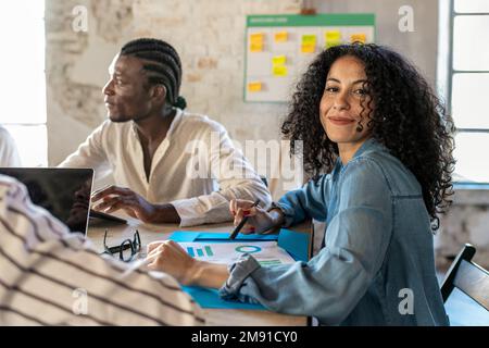 Groupe de travailleurs d'affaires travaillant ensemble, jeune belle femme arabe souriant heureux de regarder la caméra au bureau Banque D'Images