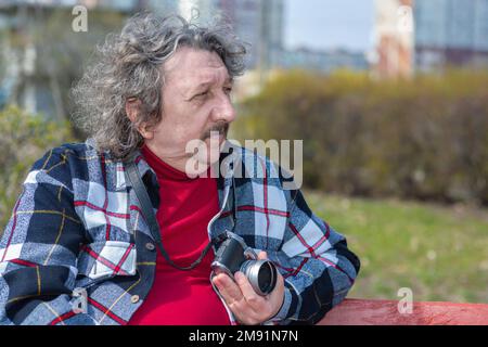 Le vieil homme est assis sur un banc. Un homme âgé est souriant. Il mérite un bon repos. Tous les problèmes laissés pour compte Banque D'Images