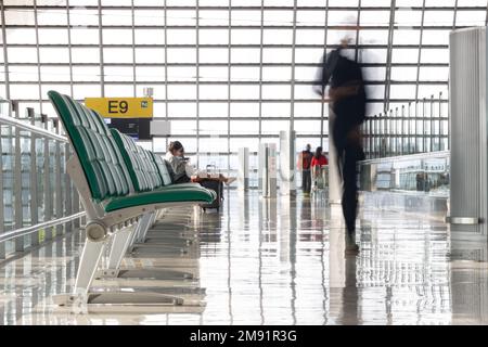 Le couloir de l'aéroport international avec des passagers à mouvement flou Banque D'Images