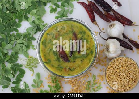 Super nourriture moringa dal ou drumstick feuilles lentille curry. Frites préparées avec des feuilles de bâton de tambour saines et nutritives. Prise de vue sur un fond blanc alon Banque D'Images