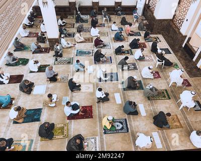Des hommes priant dans une mosquée en 2020 pendant la COVID et la distanciation sociale - pratiquant l'Islam pendant la prière du vendredi Banque D'Images
