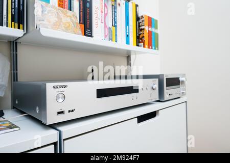 Paris, France - 13 décembre 2022 : main mâle POV pointant vers Chromecast intégré, signature certifiée sur le nouveau lecteur audio réseau Onkyo NS-6170 avec système audio haute résolution DSD et périphérique WIFI DAB DSD tapis en soie d'arrière-plan Banque D'Images