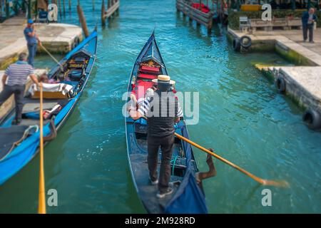 Une Gondoliere conduit son invité autour de Venise sur un petit canal latéral passant par une autre Gondola à Venise, en Italie Banque D'Images