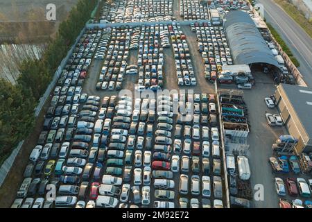 Vue aérienne du grand parking de junkyard avec des rangées de voitures brisées jetées. Recyclage des vieux véhicules Banque D'Images