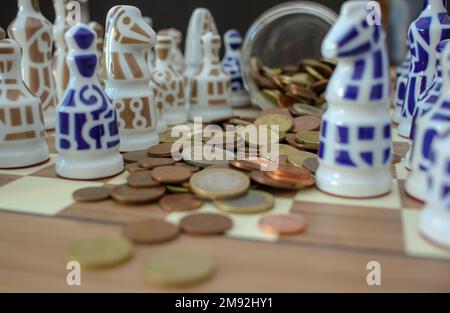 pièces en euros sur l'échiquier parmi les pièces d'échecs Banque D'Images