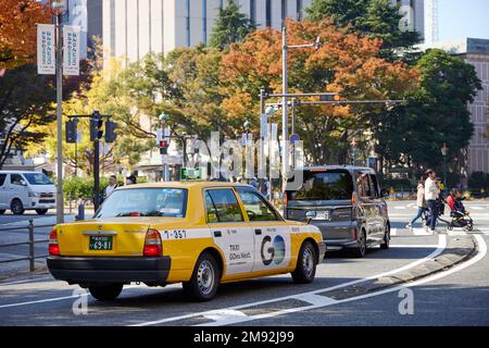 Taxi jaune attendant sur un carrefour dans les rues de Yokohama Banque D'Images