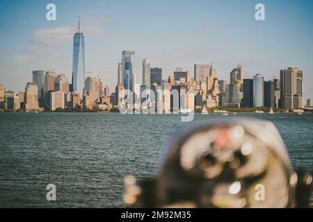 Jumelles modernes situées sur une plate-forme d'observation, près de la mer, avec des gratte-ciels dans la ville de New York sous un ciel bleu Banque D'Images