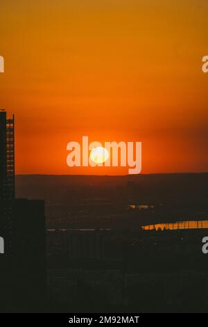 Vue pittoresque sur le ciel de coucher de soleil orange coloré avec un grand soleil jaune rond Banque D'Images