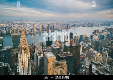 Vue aérienne de l'East River située à New York, entre des bâtiments modernes de plusieurs étages et des gratte-ciel urbains pendant la journée Banque D'Images