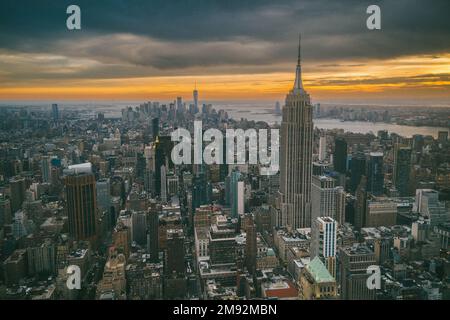 Vue aérienne des gratte-ciels et de la rivière près du célèbre grand Empire State Building à New York City au coucher du soleil en soirée Banque D'Images