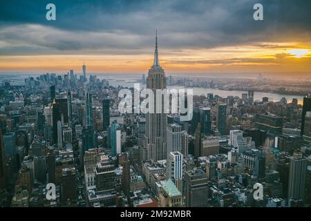 Vue aérienne des gratte-ciels et de la rivière près du célèbre grand Empire State Building à New York City au coucher du soleil en soirée Banque D'Images