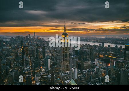 Vue aérienne des gratte-ciels et de la rivière près du célèbre grand Empire State Building à New York City au coucher du soleil en soirée Banque D'Images