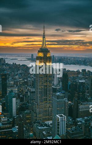 Vue aérienne des gratte-ciels et de la rivière près du célèbre grand Empire State Building à New York City au coucher du soleil en soirée Banque D'Images