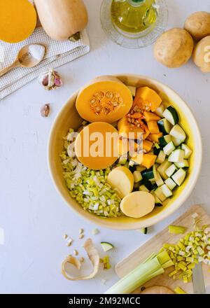 Vue de dessus de la citrouille en tranches et des courgettes dans le bol pendant la préparation de la soupe à la crème de citrouille Banque D'Images