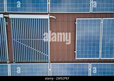 Panneaux photovoltaïques et capteurs solaires d'air à vide pour le chauffage de l'eau et la production d'électricité propre montés sur le toit de la maison. Production de Banque D'Images