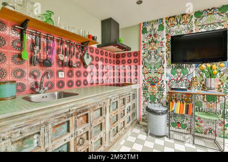 Intérieur d'une cuisine spacieuse et lumineuse de style mexicain avec réfrigérateur noir et placards en bois placés près des murs colorés avec des carreaux décoratifs Banque D'Images