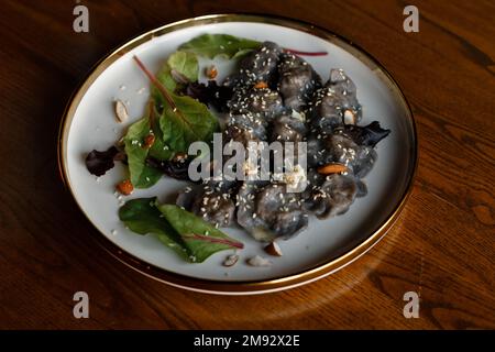 Un morceau de saumon grillé poivre citron et sel sur une assiette brune avec des feuilles de laitue. arrière-plan en bois. Photo de haute qualité Banque D'Images