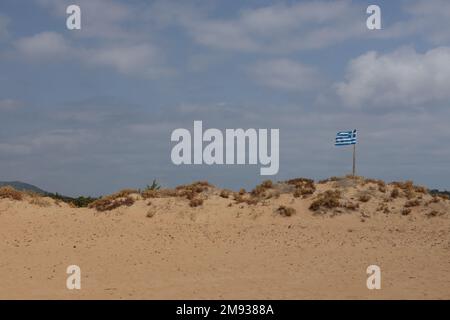 Drapeau grec sur une plage pittoresque, drapeau volant sur une dune. Banque D'Images