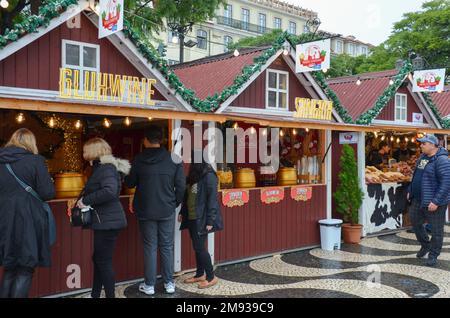 Marché de Noël de Rossio à la place Rossio à Lisbonne, Portugal. Les visiteurs goûtant du vin au stand de Gluhwine. Novembre 2022. Banque D'Images