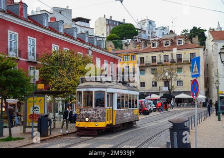 Le tramway jaune à Largo Portas do sol dans le quartier d'Alfama. Le tramway E28 s'arrête près de la statue de Saint Vincente à Lisbonne, au Portugal. Novembre 2022. Banque D'Images