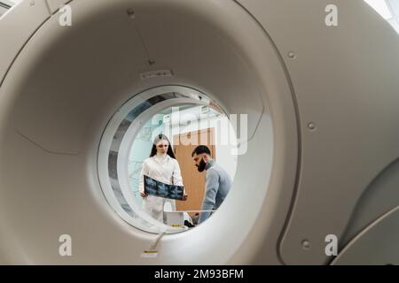 MRI Doctor montre des rayons X de l'abdomen de l'homme patient. Consultation après un examen IRM en clinique médicale Banque D'Images