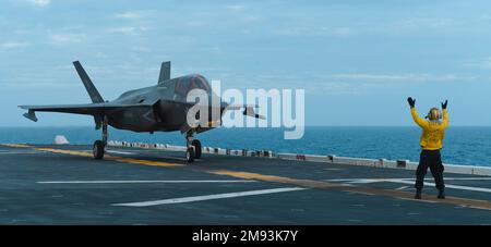 MER DES PHILIPPINES (14 janvier 2023) Aviation Boatswain's Mate (Handling) 1st classe Travion Humphrey, de Sacramento, Californie, affecté au transporteur d'assaut amphibie USS America (LHA 6), Ordonne à un F-35B Lightning II de l’escadron d’attaque de chasseurs maritimes (VMFA) 242 de décoller du pont de vol du navire en cours dans la mer des Philippines, au Japon, le 14 janvier. L'Amérique, navire chef de file du America Amphiobie Ready Group, opère dans la zone d'opérations de la flotte 7th pour améliorer l'interopérabilité avec les alliés et les partenaires et servir de force de réaction prête à défendre la paix et Banque D'Images