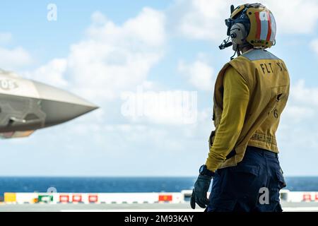 OKINAWA (Japon) (12 janvier 2023) Aviation Boatswain’s Mate (Handling) 2nd Class Kenny NGO, d’Upland (Californie), affecté au transporteur d’assaut amphibie déployé vers l’avant USS America (LHA 6), dirige un F-35B Lightning II du Marine Fighter Attack Squadron (VMFA) 242 avant le décollage, alors qu’il est en cours dans les environs d’Okinawa (Okinawa). Japon, le 12 janvier. L'Amérique, navire chef de file du America Amphiobie Ready Group, opère dans la zone d'opérations de la flotte 7th pour améliorer l'interopérabilité avec les alliés et les partenaires et servir de force de réaction prête à l'emploi pour défendre la paix et la stabilité dans l'Ind Banque D'Images