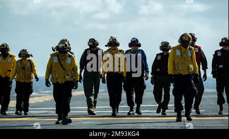 OKINAWA, Japon (12 janvier 2023) des marins affectés au porte-avions amphibie déployé à l'avant USS America (LHA 6) et des Marines affectés au Marine Fighter Attack Squadron (VMFA) 242 effectuent une promenade sur le pont de vol du navire en cours dans les environs d'Okinawa, au Japon, le 12 janvier. L'Amérique, navire chef de file du America Amphiobie Ready Group, opère dans la zone d'opérations 7th de la flotte pour améliorer l'interopérabilité avec ses alliés et ses partenaires et servir de force de réaction prête à l'emploi pour défendre la paix et la stabilité dans la région Indo-Pacifique. (É.-U. Photo de la marine par Mass Communica Banque D'Images