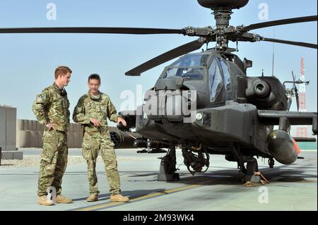 NOTE DES ÉDITEURS: Suite à une demande du ministère de la Défense, le bureau de l'AP a brouillé les visages du personnel de service qui apparaissent sur ces photos à côté du duc de Sussex. Photo du dossier datée du 07/09/12 du Prince Harry qui est montré la ligne de vol Apache par un membre de son escadron (nom non fourni) au Camp Bastion en Afghanistan, d'où il sera en service pendant son voyage de service comme copilote tireur. Date de publication : lundi 16 janvier 2023. Banque D'Images