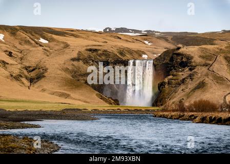 Vue lointaine de la magnifique cascade de Skógafoss, vue de la route 1 / route périphérique sur l'eau de la rivière Skóga, région sud, Islande Banque D'Images