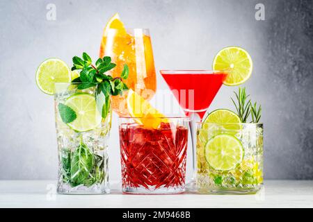 Ensemble de cocktails tendance les plus populaires : aperol spritz, negroni, mojito, gin tonique et cosmopolite sur fond de comptoir gris Banque D'Images