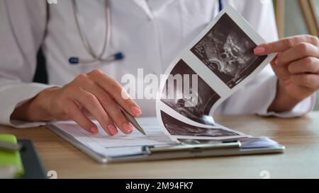 Gros plan de la femme médecin vérifiant les résultats médicaux sur le lieu de travail en clinique. Banque D'Images