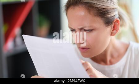 Gros plan d'une femme avec un document de lecture sérieux du visage. Banque D'Images