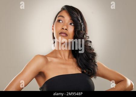 Les cheveux magnifiques sont la meilleure vengeance. une belle jeune femme posant sur un fond gris. Banque D'Images