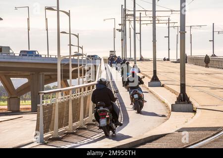 Une moto de groupe circule dans une rangée de la ville Banque D'Images