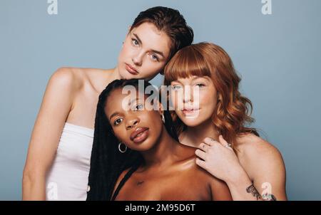 Femmes avec différents tissus de peau regardant la caméra dans un studio. Groupe de jeunes femmes confiantes se sentant à l'aise dans leur peau naturelle. Trois dbo Banque D'Images