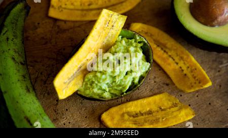 Croustilles de banane au guacamole. Le guacamole est une trempette, une tartinade ou une salade à base d'avocat, développée pour la première fois au Mexique. Banque D'Images