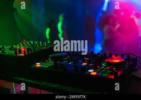 Tableau de mixage pour DJ professionnels sous lumières colorées dans la cabine de contrôle Banque D'Images