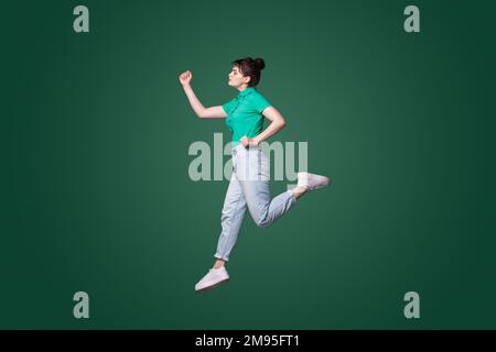 Pleine photo de profil de la femme attrayante runaway voulant venir premier dans le matin isolé couleur de fond vert. Banque D'Images